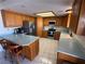 The eat-in kitchen features stainless appliances, wood cabinetry, tile floor and a breakfast bar at 1540 Labrador St, Pahrump, NV 89048