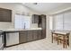 Well-lit kitchen with dark cabinetry, stainless steel appliances, and a dining area at 1709 Autumn Rust Dr, Las Vegas, NV 89119