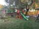 Backyard with a wooden playset, slide, swings, and artificial grass at 1800 Quail Point Ct, Las Vegas, NV 89117