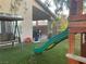 Backyard with a wooden playset, slide, swing, seating, and artificial grass at 1800 Quail Point Ct, Las Vegas, NV 89117