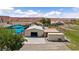 Aerial view of the property featuring a large garage, an in-ground pool, and desert landscaping at 1988 N Moapa Valley Blvd, Logandale, NV 89021