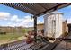 View of the home's backyard featuring metal fencing, a large water tank, and a wooden pergola at 1988 N Moapa Valley Blvd, Logandale, NV 89021