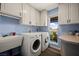 Bright laundry room with white cabinets, LG washer and dryer, sink and a window with a water view at 1988 N Moapa Valley Blvd, Logandale, NV 89021