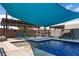 Backyard pool features a sunshade, outdoor seating, and lush landscaping at 1988 N Moapa Valley Blvd, Logandale, NV 89021