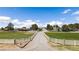 Long driveway leading to residences, surrounded by sprawling green lawns and white fencing at 1988 N Moapa Valley Blvd, Logandale, NV 89021