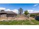 Fenced backyard area with patchy grass, mature trees, and a view of the distant mountains at 1988 N Moapa Valley Blvd, Logandale, NV 89021