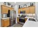 Kitchen featuring stainless steel appliances, wood cabinets, and white countertops at 234 Priority Point St, Henderson, NV 89012