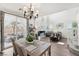 Bright living room with cathedral ceilings, modern chandelier, and access to a private outdoor patio area at 234 Priority Point St, Henderson, NV 89012