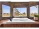 A deep soaking tub with beautiful natural light and views of the yard at 2445 Ping Dr, Henderson, NV 89074
