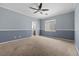 Spacious carpeted bedroom with two-tone paint, ceiling fan, and ensuite bathroom at 2445 Ping Dr, Henderson, NV 89074