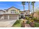 Stunning two-story home featuring a three-car garage, lush landscaping, and a welcoming entrance at 2445 Ping Dr, Henderson, NV 89074