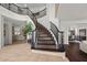 Grand foyer with a curved staircase, elegant tile flooring, and views into the dining and living areas at 2445 Ping Dr, Henderson, NV 89074