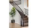 Elegant curved staircase with dark wood treads, contrasting risers, and potted plant at 2445 Ping Dr, Henderson, NV 89074