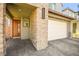 Inviting front porch with stone accents leading to a modern wood front door and two-car garage at 41 Strada Moscato, Henderson, NV 89011