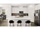 Modern white kitchen with a central island, stainless appliances, and stylish backsplash at 41 Strada Moscato, Henderson, NV 89011