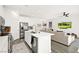 Open concept kitchen with stainless steel appliances, island with seating, and easy flow into the living area at 41 Strada Moscato, Henderson, NV 89011