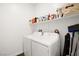 Efficient laundry room with a washer, dryer, and shelving for storage at 41 Strada Moscato, Henderson, NV 89011