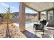 Inviting covered patio featuring stone pillars, a built-in grill, seating, and a refreshing pool with mountain views at 41 Strada Moscato, Henderson, NV 89011