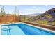 View of a backyard pool with mountain views and mature landscaping behind the fence at 41 Strada Moscato, Henderson, NV 89011