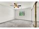 Bedroom with plush neutral carpet, white walls, a ceiling fan, large window, and mirror closet doors at 4216 Thunder Twice St, Las Vegas, NV 89129