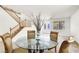 Elegant dining area with staircase and a glass-top table with four upholstered chairs at 4216 Thunder Twice St, Las Vegas, NV 89129