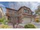 Two-story home featuring a terracotta roof, muted pink shutters, and a three-car garage at 4216 Thunder Twice St, Las Vegas, NV 89129