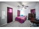 This bedroom has a ceiling fan, carpet, and purple curtains at 4440 Pacific Crest Ave, Las Vegas, NV 89115