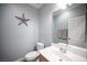 Well-lit half bathroom features a star decoration, a wood vanity, and a neutral color scheme at 4440 Pacific Crest Ave, Las Vegas, NV 89115