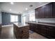 A kitchen showcases dark cabinetry, an island with stone accents, and modern appliances at 4440 Pacific Crest Ave, Las Vegas, NV 89115