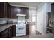 Kitchen featuring white range, dark cabinetry, and stainless steel appliances, including a refrigerator with beverage center at 4440 Pacific Crest Ave, Las Vegas, NV 89115