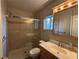 Bright bathroom featuring a glass-enclosed shower, wood vanity, and medicine cabinet with Hollywood-style lights at 4770 Topaz St # 73, Las Vegas, NV 89121