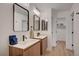 Modern bathroom featuring double sinks, wood cabinets, sleek black hardware, and bright lighting fixtures at 5071 Pioneer Ave # 203, Las Vegas, NV 89146