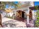 An inviting backyard featuring an arched covered patio, lush greenery, and a cozy seating area, ideal for relaxing outdoors at 5325 Sandstone Dr, Las Vegas, NV 89142