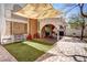 Inviting outdoor space with a shade sail, manicured artificial grass, and a charming covered patio for comfortable living at 5325 Sandstone Dr, Las Vegas, NV 89142