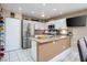 Well-lit kitchen with white cabinets, stainless steel refrigerator, and a breakfast bar with seating at 5325 Sandstone Dr, Las Vegas, NV 89142