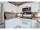 Charming kitchen with white cabinetry, granite countertops, and modern appliances for a cozy cooking experience at 5325 Sandstone Dr, Las Vegas, NV 89142