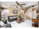 Comfortable living room featuring a ceiling fan, tile flooring, and a staircase with unique accents at 5325 Sandstone Dr, Las Vegas, NV 89142