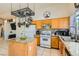 Bright kitchen featuring a center island with granite countertops, pot rack, and stainless steel appliances at 5353 Dandelion Ct, North Las Vegas, NV 89031