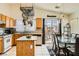 Bright eat-in kitchen with tile floors, wood cabinets, stainless steel appliances, and glass slider to backyard at 5353 Dandelion Ct, North Las Vegas, NV 89031