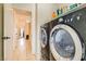 Laundry room with modern black washer and dryer next to a hallway at 5353 Dandelion Ct, North Las Vegas, NV 89031