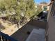 Backyard view from the balcony with a tree, gravel, and sitting area at 5425 Whisper Bluff St, North Las Vegas, NV 89031