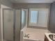 Bathroom with tub, shower, and window with white shutters at 5425 Whisper Bluff St, North Las Vegas, NV 89031