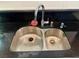 Stainless steel double kitchen sink with chrome faucet, situated on a black countertop at 5425 Whisper Bluff St, North Las Vegas, NV 89031