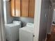 Home laundry room equipped with a washer, dryer, and wood storage cabinets at 5425 Whisper Bluff St, North Las Vegas, NV 89031