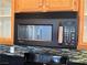 Magic Chef microwave and mosaic backsplash, with wood cabinets in a home kitchen at 5425 Whisper Bluff St, North Las Vegas, NV 89031