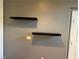 Stylish gray wall with minimalist black floating shelves, adding modern flair to the room at 5425 Whisper Bluff St, North Las Vegas, NV 89031