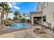 A luxurious backyard pool with a waterfall and spa, accompanied by a fire pit and lush landscaping at 5588 Holcomb Bridge Ct, Las Vegas, NV 89149