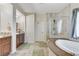 Bathroom featuring dual sinks, soaking tub, glass shower and tiled floors at 5588 Holcomb Bridge Ct, Las Vegas, NV 89149