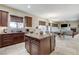 Spacious kitchen with granite countertops, dark wood cabinets, island, and seamless access to the dining area at 5588 Holcomb Bridge Ct, Las Vegas, NV 89149