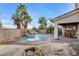 Backyard pool and spa with rock waterfall feature, complemented by a fire pit and palm trees at 5588 Holcomb Bridge Ct, Las Vegas, NV 89149